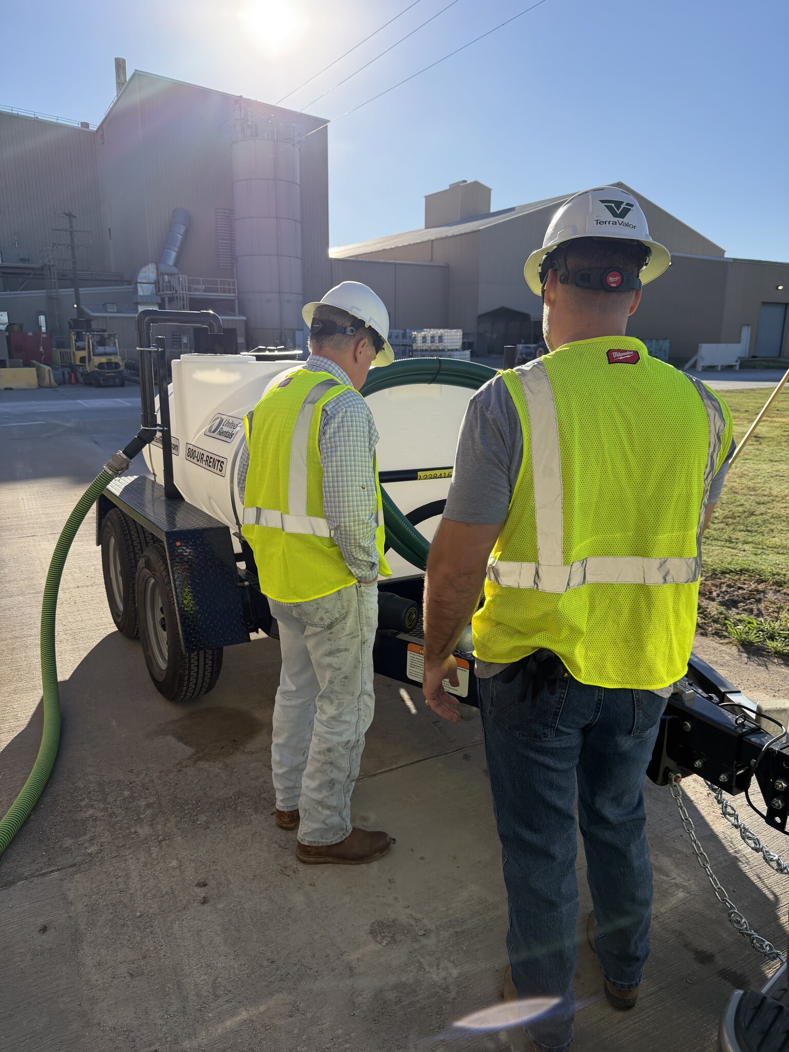 TerraValor team members preparing a water trailer at an industrial manufacturing facility